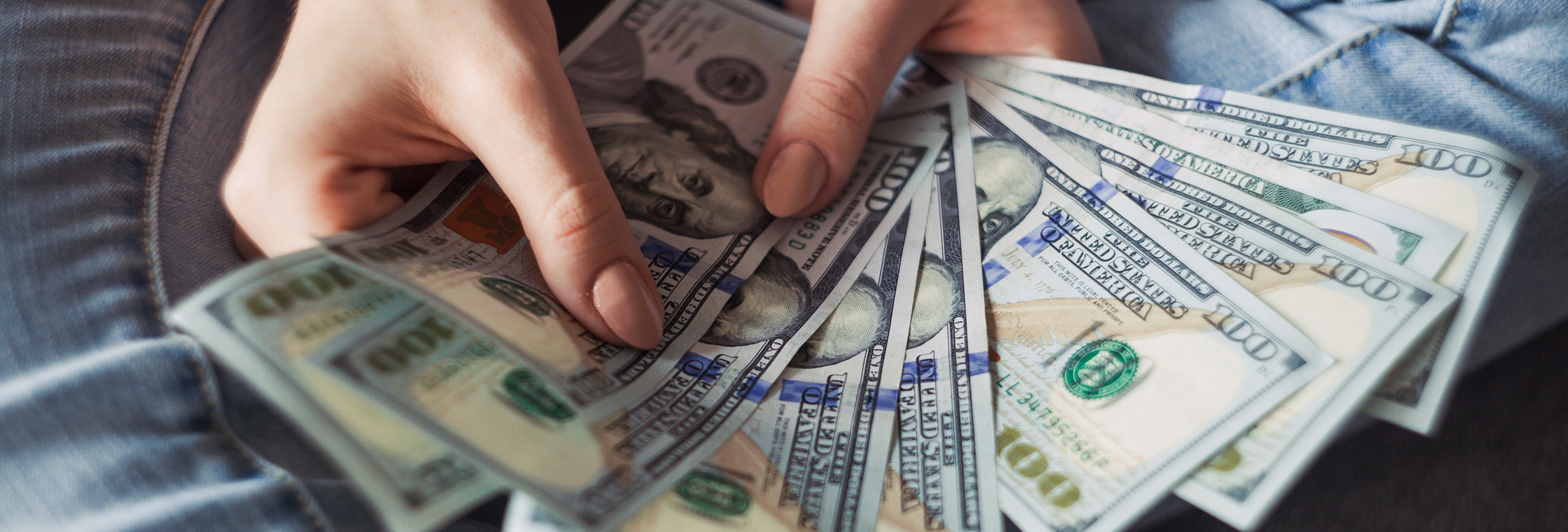 Money fanned out being held in a woman's hands